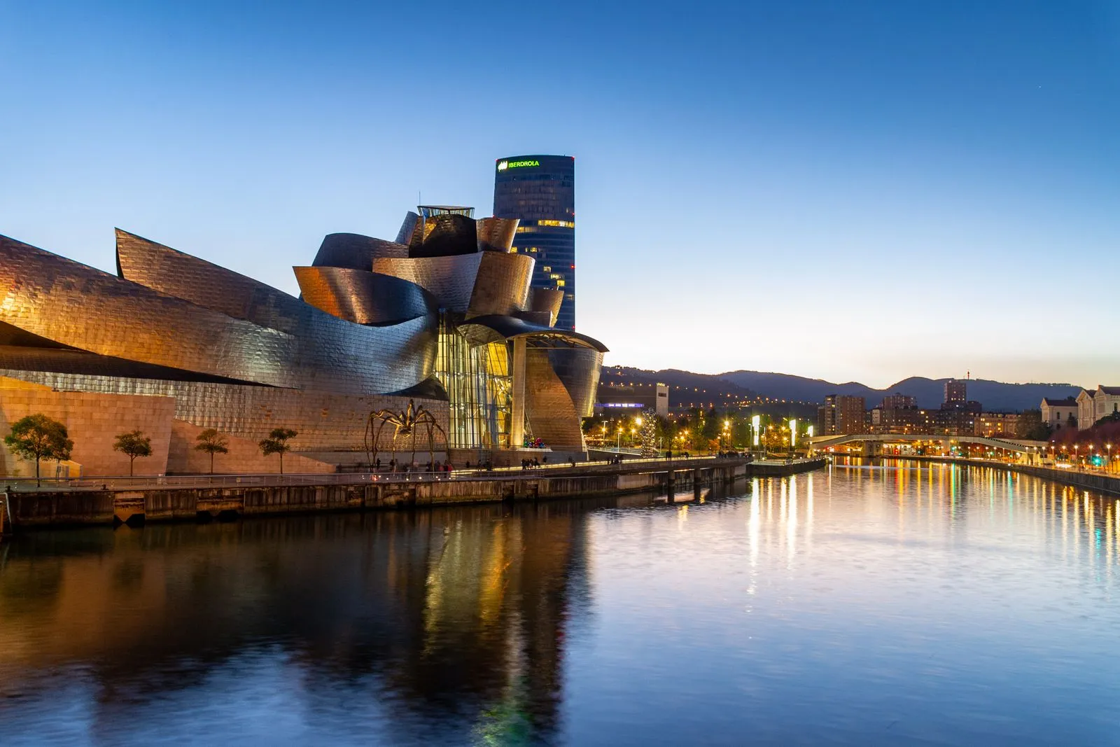 Muzeul Guggenheim din Bilbao reflectat în râul Nervión la apus