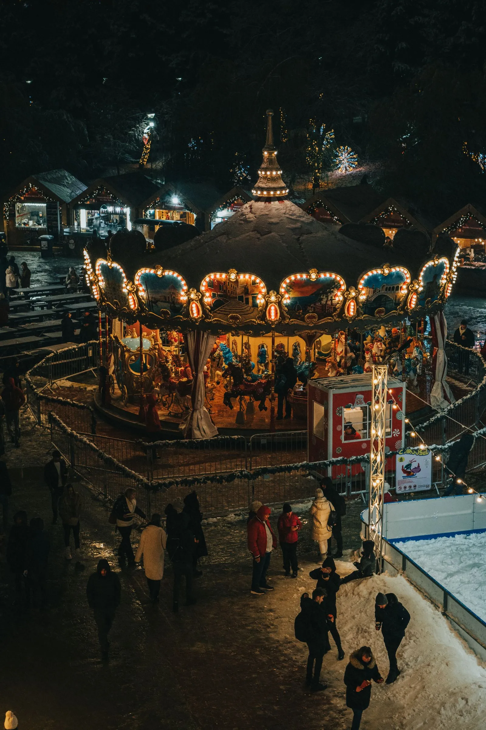 Carusel luminat la un târg de Crăciun din București, fotografiat de sus, noaptea