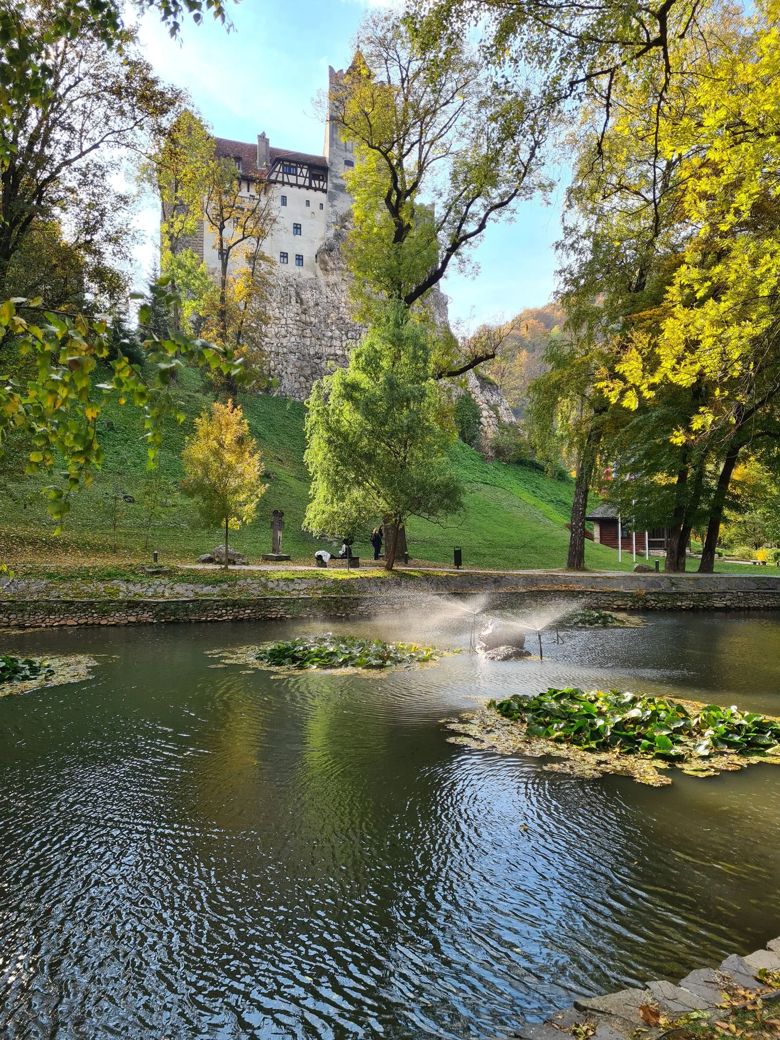 Lacul din Parcul Regal de la Bran toamna, cu castelul pe stâncă în fundal