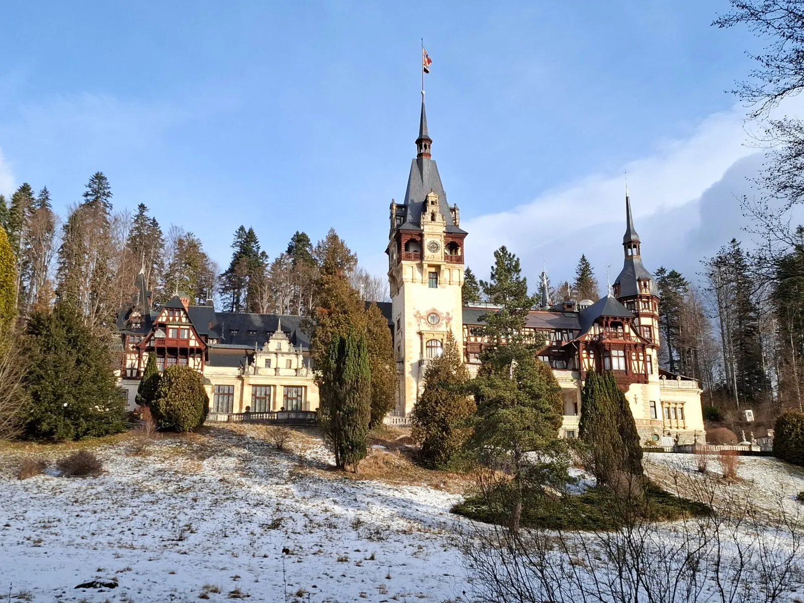 Castelul Peleș iarna, cu zăpadă pe peluza din fața castelului