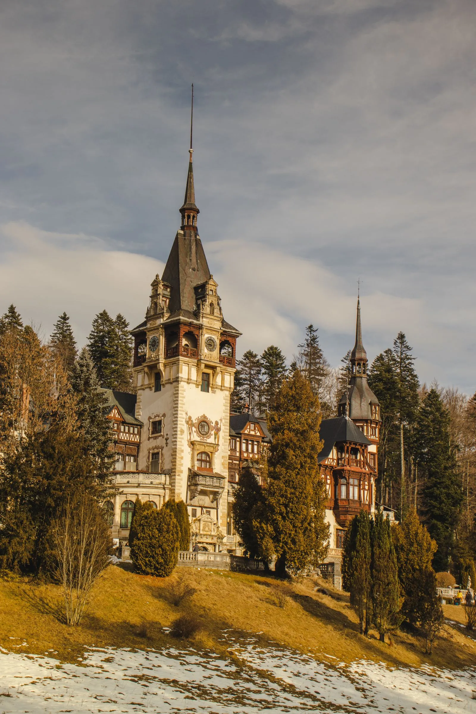 Turnul principal al Castelului Peleș din Sinaia, între brazi, la sfârșit de toamnă