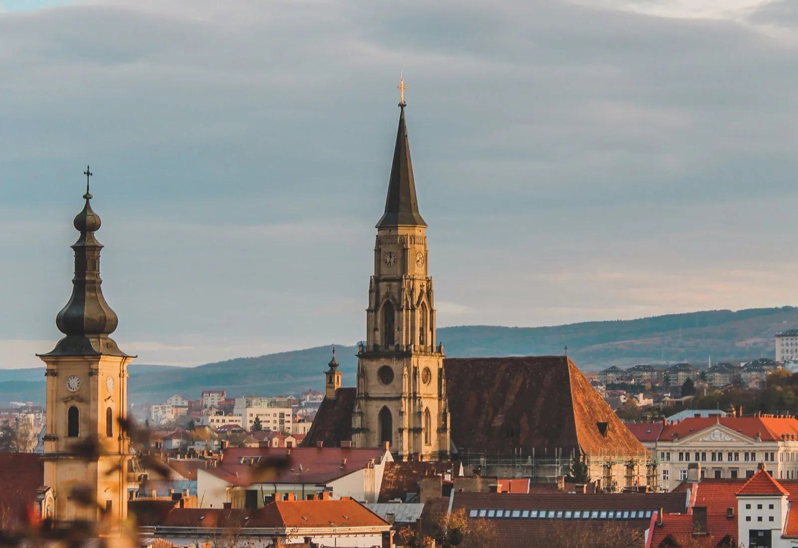 Centrul vechi din Cluj-Napoca la apus, cu turnul Bisericii Sfântul Mihail și acoperișurile din jurul Pieței Unirii
