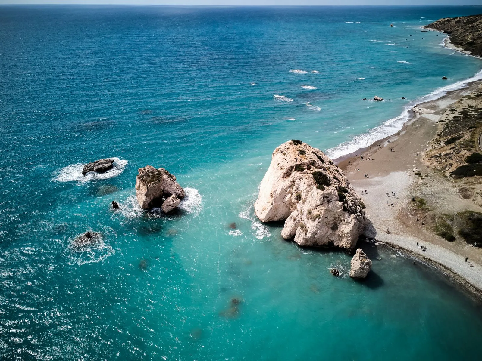 Stânca Afroditei (Petra tou Romiou) de lângă Paphos, Cipru, văzută de sus, cu apă turcoaz și plaja de pietriș