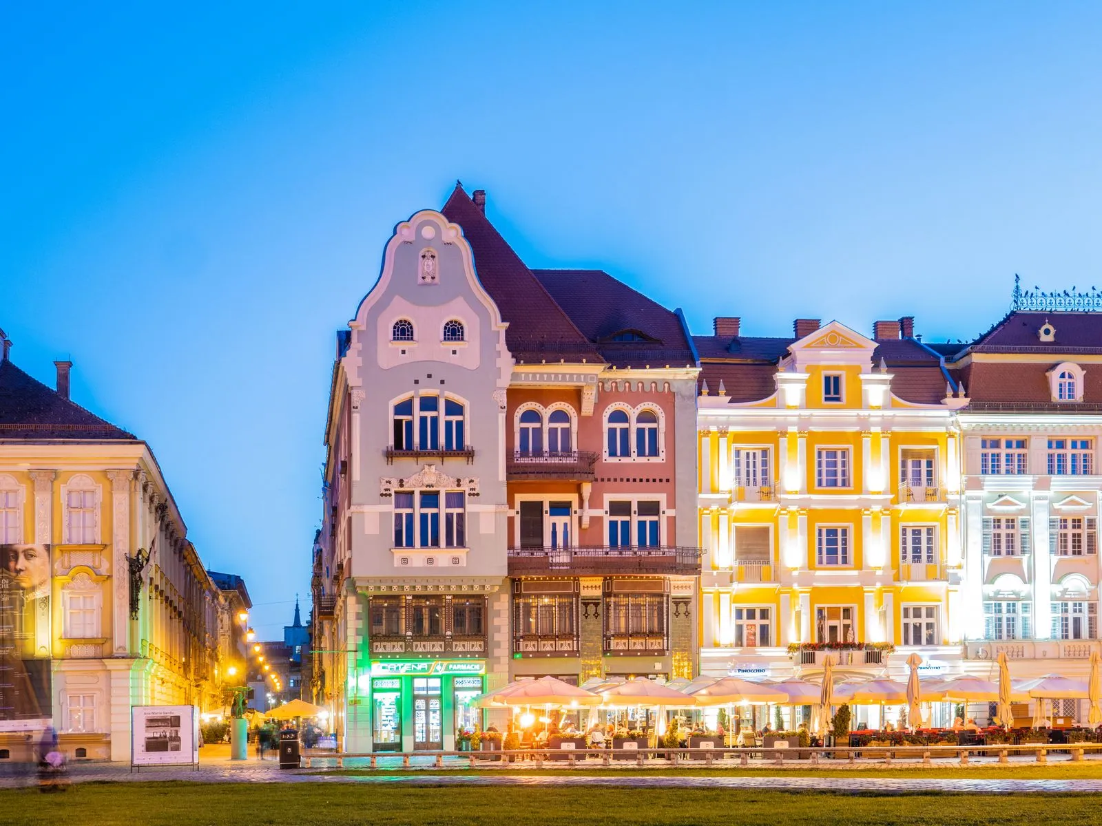 Clădiri colorate iluminate în Piața Unirii din Timișoara, seara