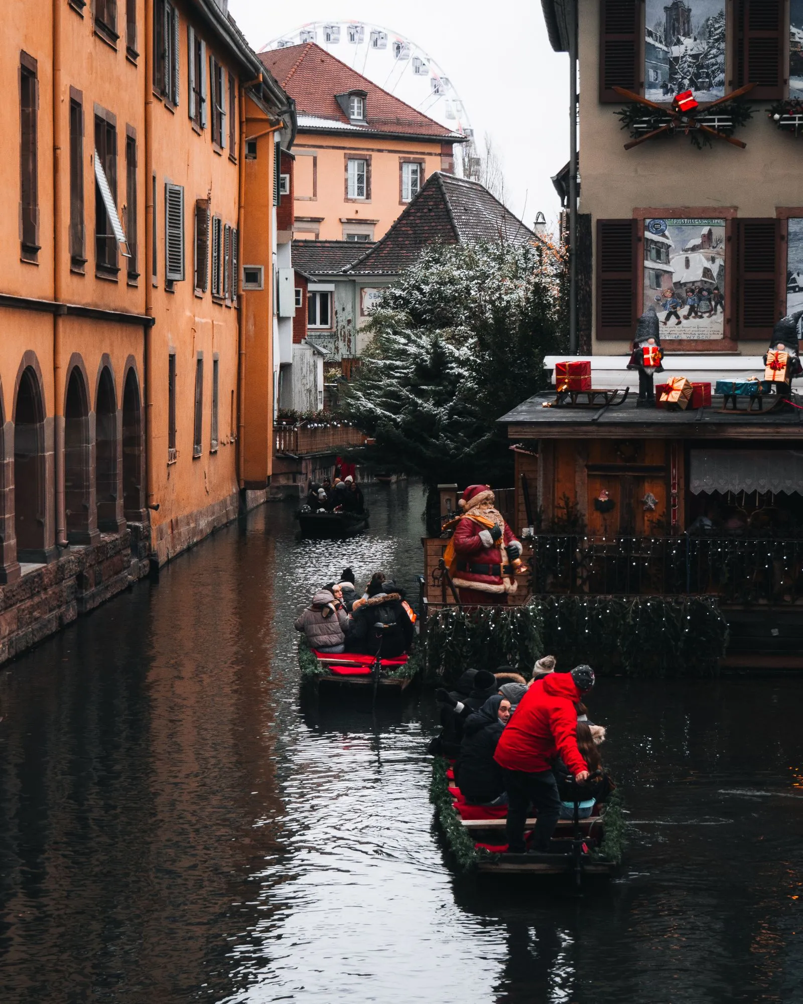 Bărci pe canalul din Petite Venise, Colmar, iarna, cu roata panoramică în fundal