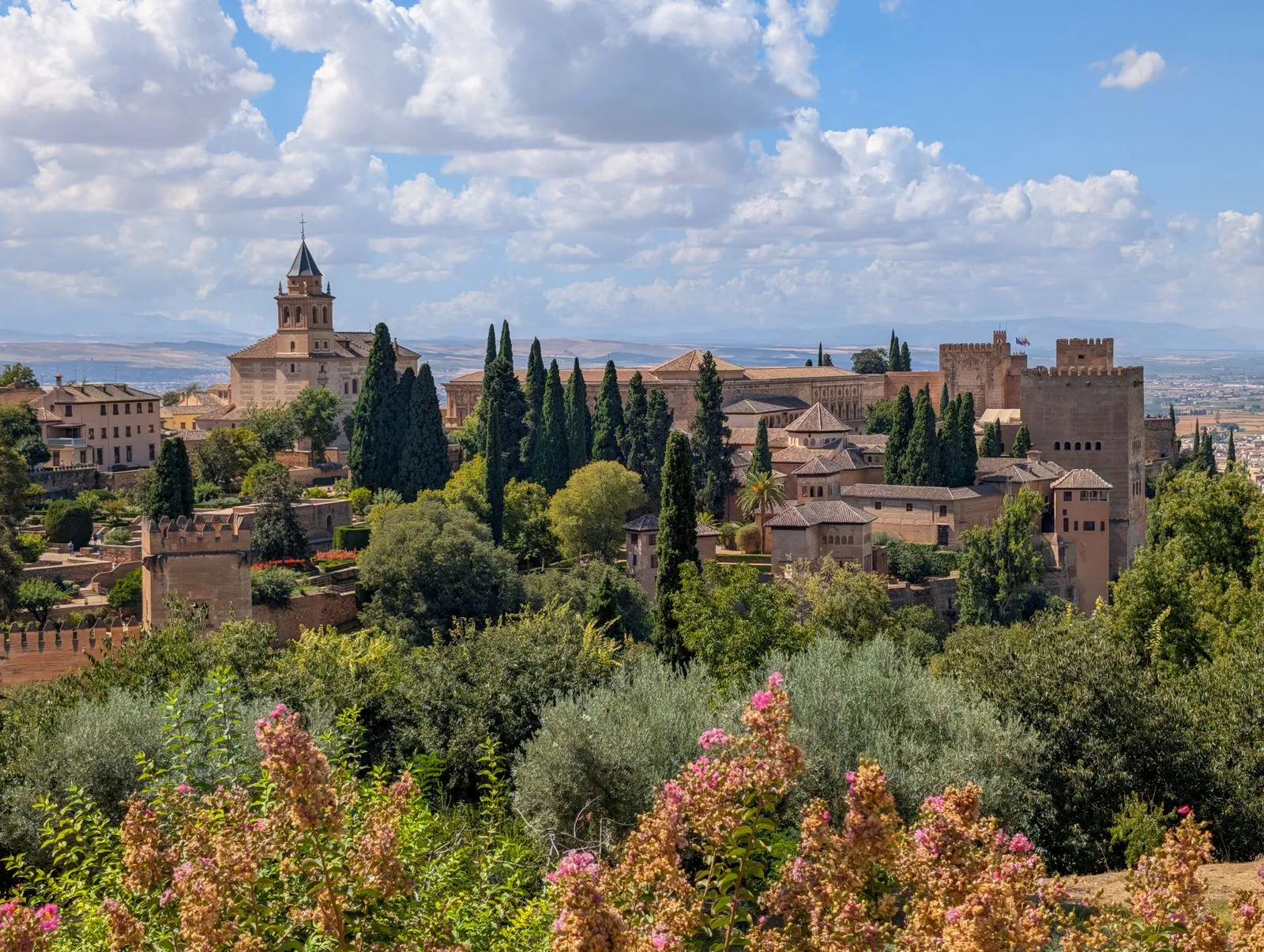 Alhambra din Granada văzută peste grădini, cu turnurile fortăreței