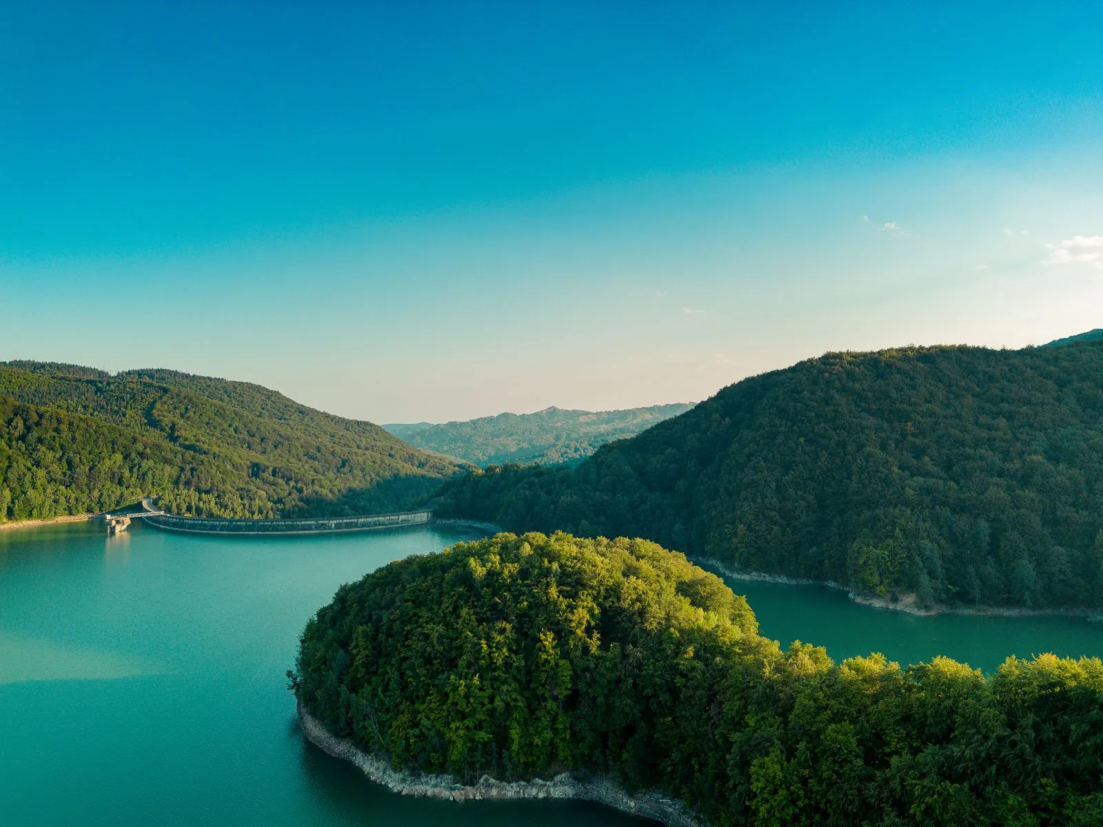Lacul Paltinu din Valea Doftanei văzut de sus, cu pădurile și munții din jur