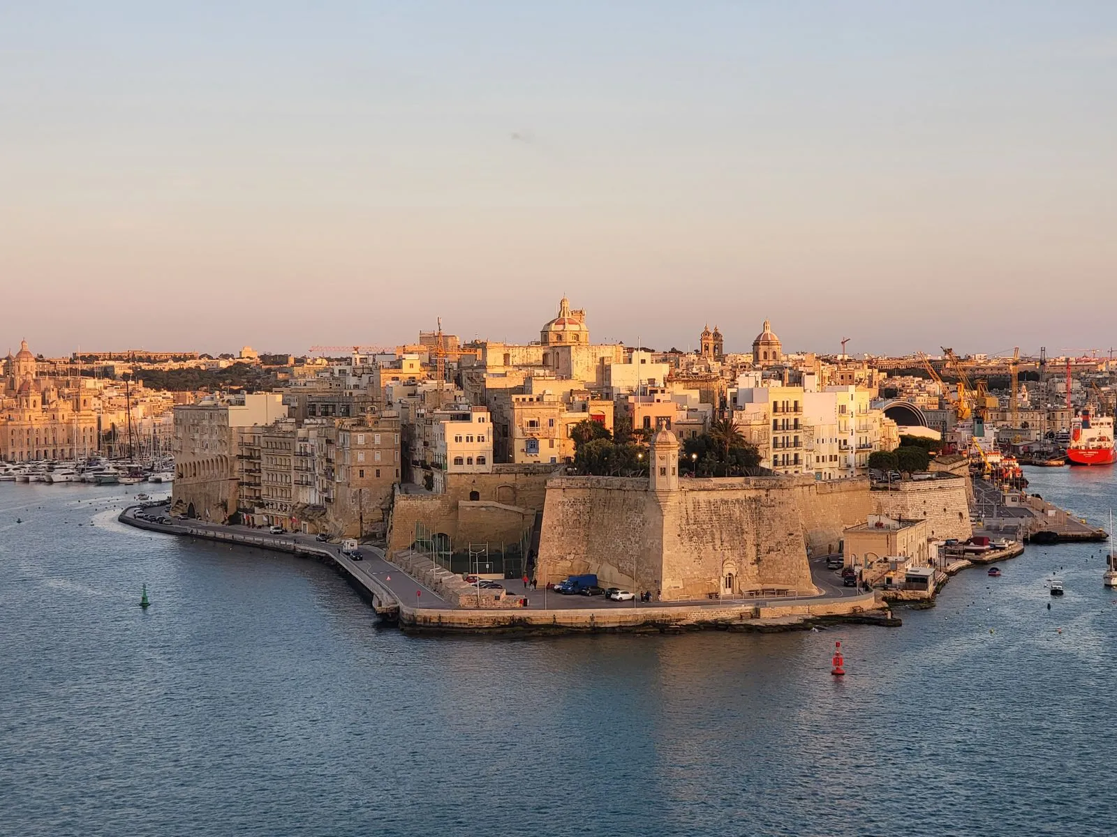 Fortificațiile de piatră din Grand Harbour, Malta, la apus, cu bărci în port