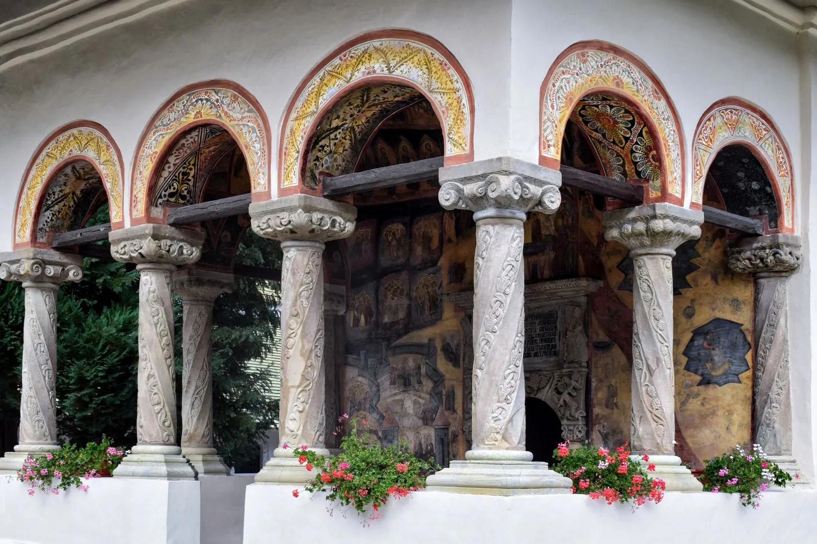 Pridvor cu coloane de piatră sculptate și fresce la Mănăstirea Sinaia