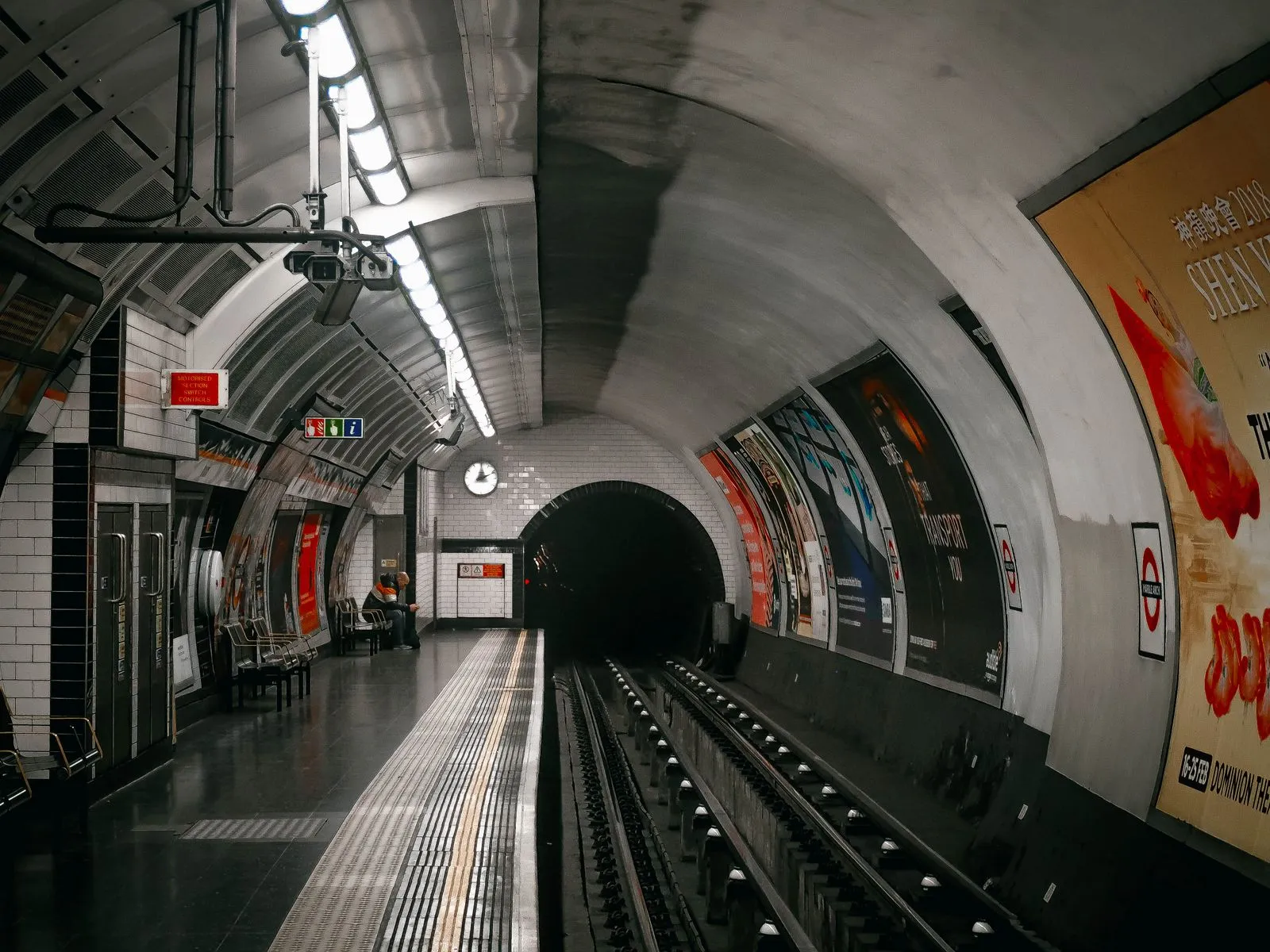 Peron de metrou London Underground, cu tunelul și panourile stației