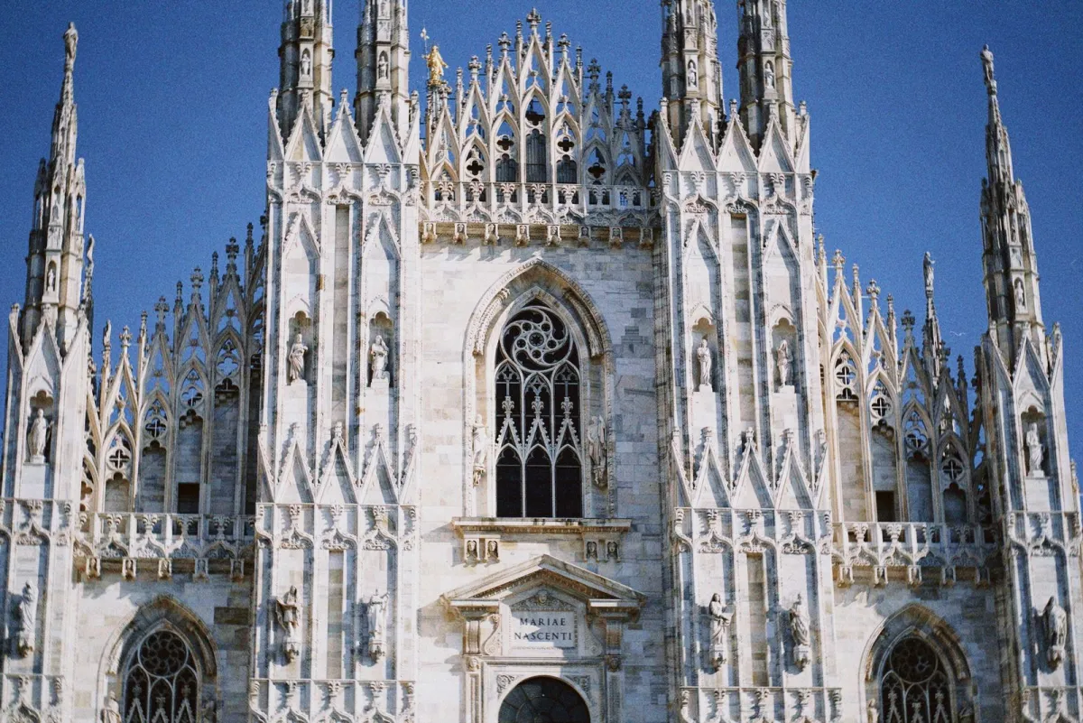 Fațada gotică a Domului din Milano, cu turlele și statuile de marmură albă