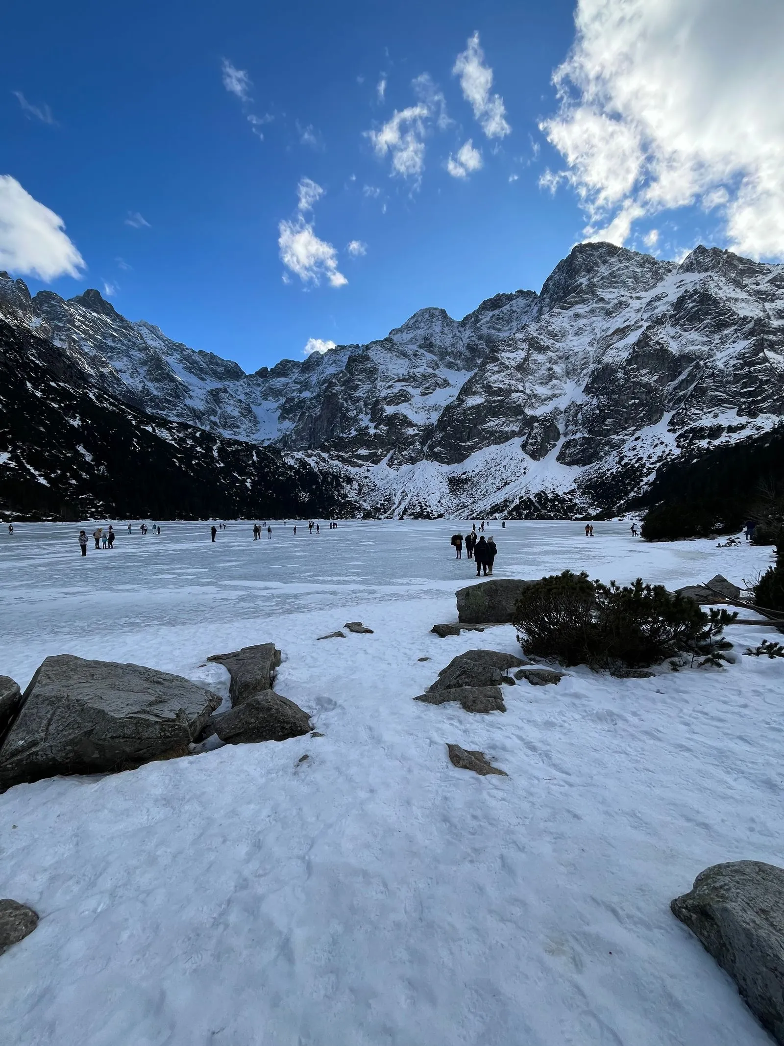 Lacul Morskie Oko înghețat și acoperit de zăpadă, sub vârfurile Tatrei Înalte
