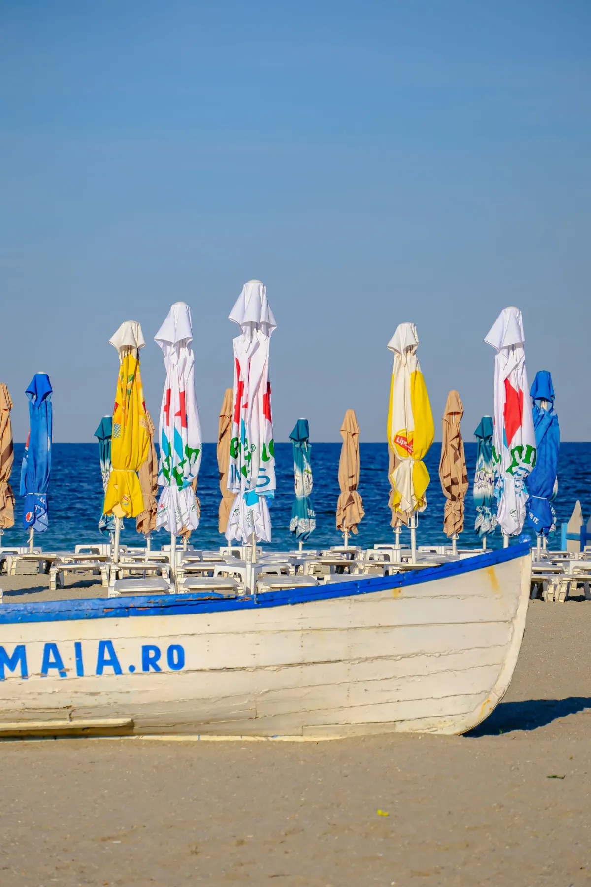 Barcă de salvamar și umbrele colorate pe plaja din Mamaia Nord