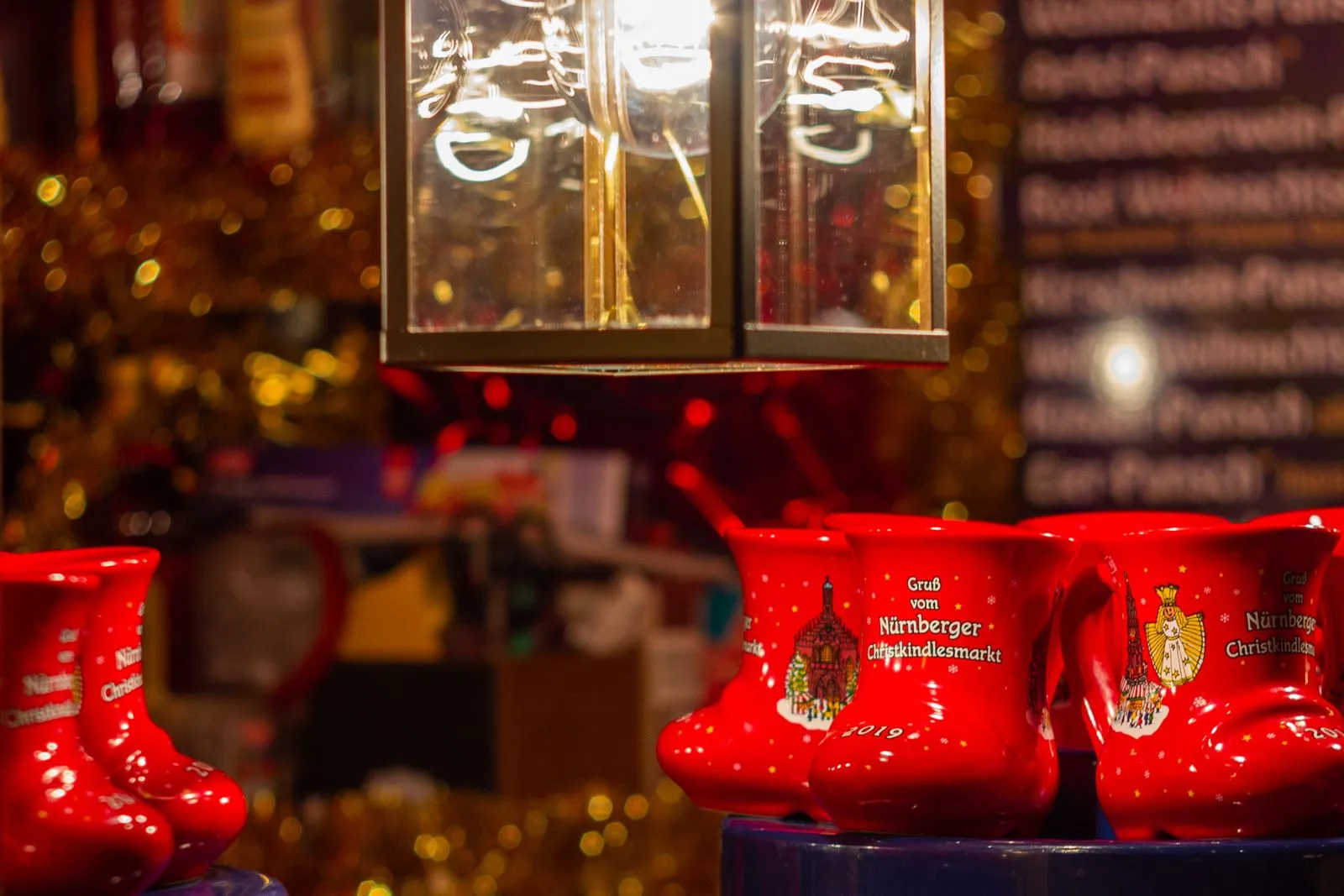 Căni roșii de Glühwein în formă de cizmă, cu inscripția Nürnberger Christkindlesmarkt