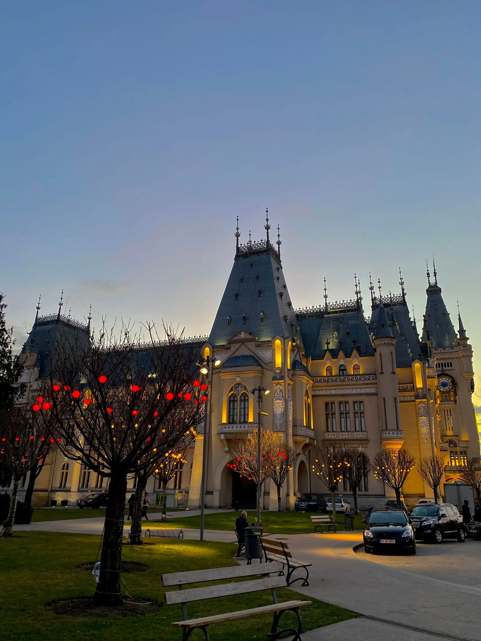 Palatul Culturii din Iași la apus, cu pomii din parc împodobiți cu globuri de lumină