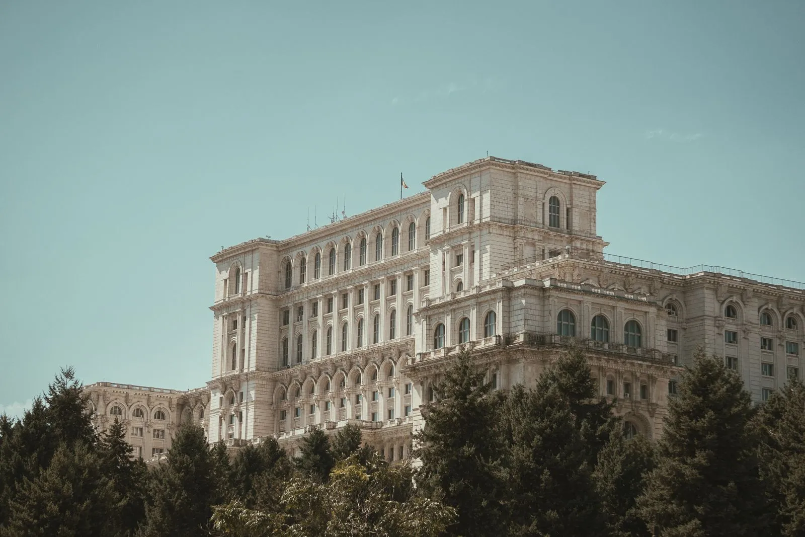 Corpul central al Casei Poporului deasupra copacilor, dinspre latura de nord