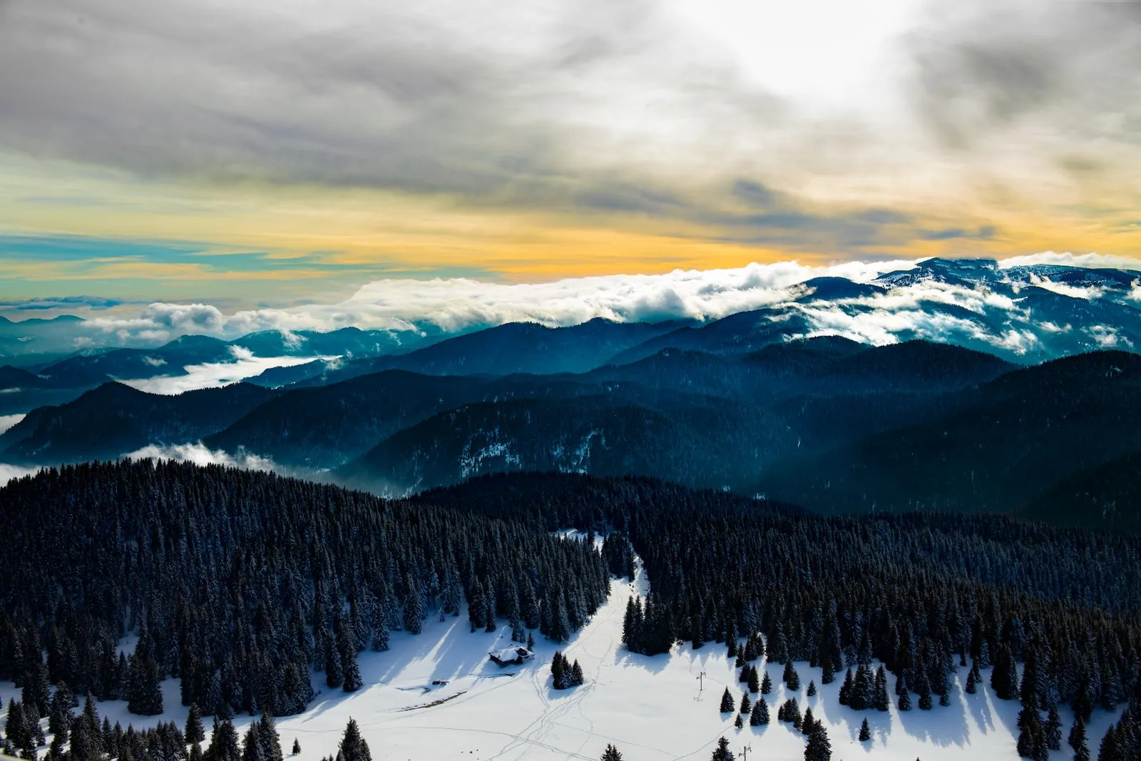 Vedere aeriană peste pădurile înzăpezite și Munții Rodopi de la Pamporovo, Bulgaria