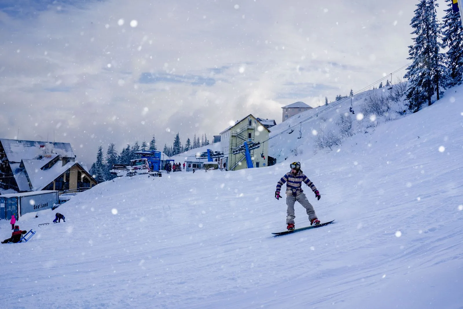 Snowboarder pe pârtia de la Holda, în Bucovina, într-o zi cu ninsoare