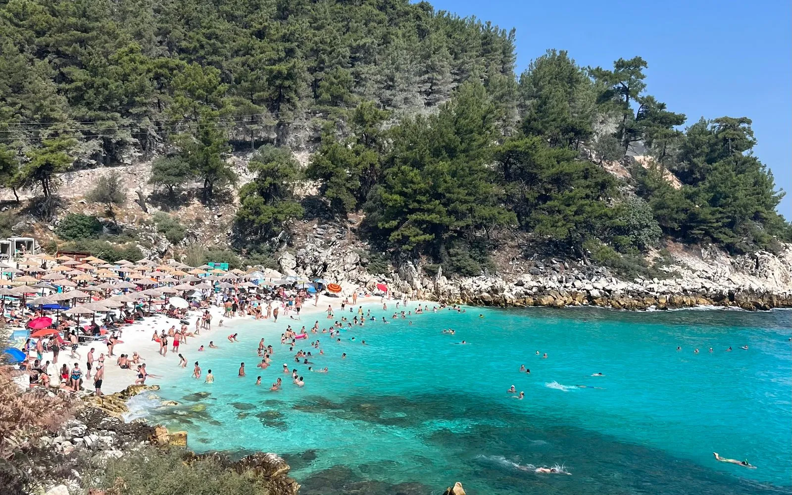 Golf cu apă turcoaz și pini pe coasta insulei Thassos