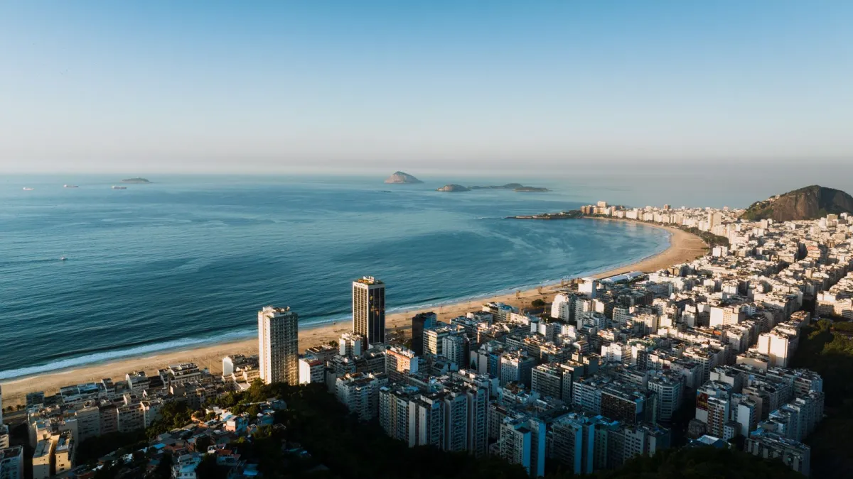 Plaja Copacabana din Rio de Janeiro văzută de sus, cu blocurile de pe faleză și oceanul