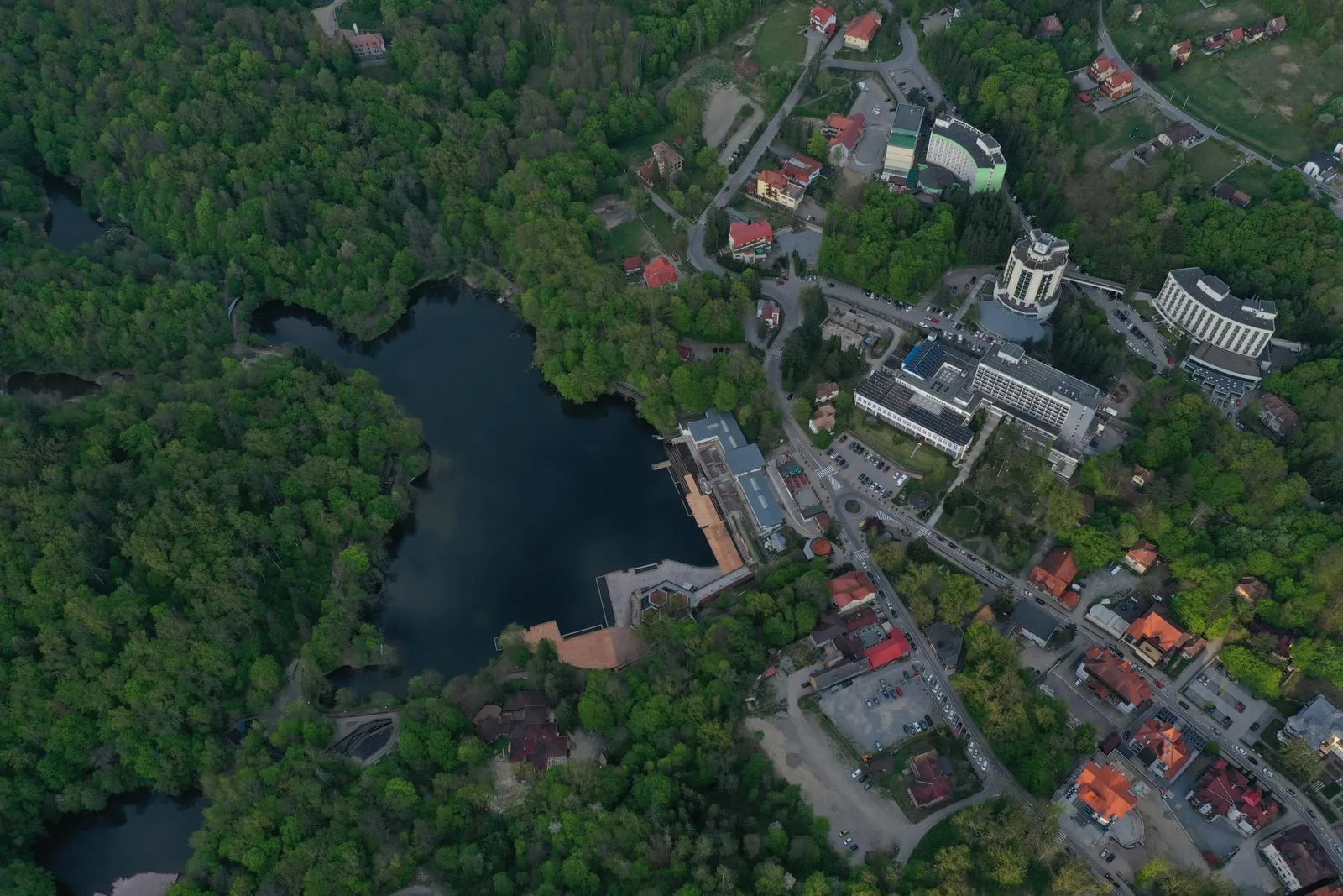 Vedere aeriană asupra Sovatei, cu Lacul Ursu înconjurat de pădure și hotelurile stațiunii