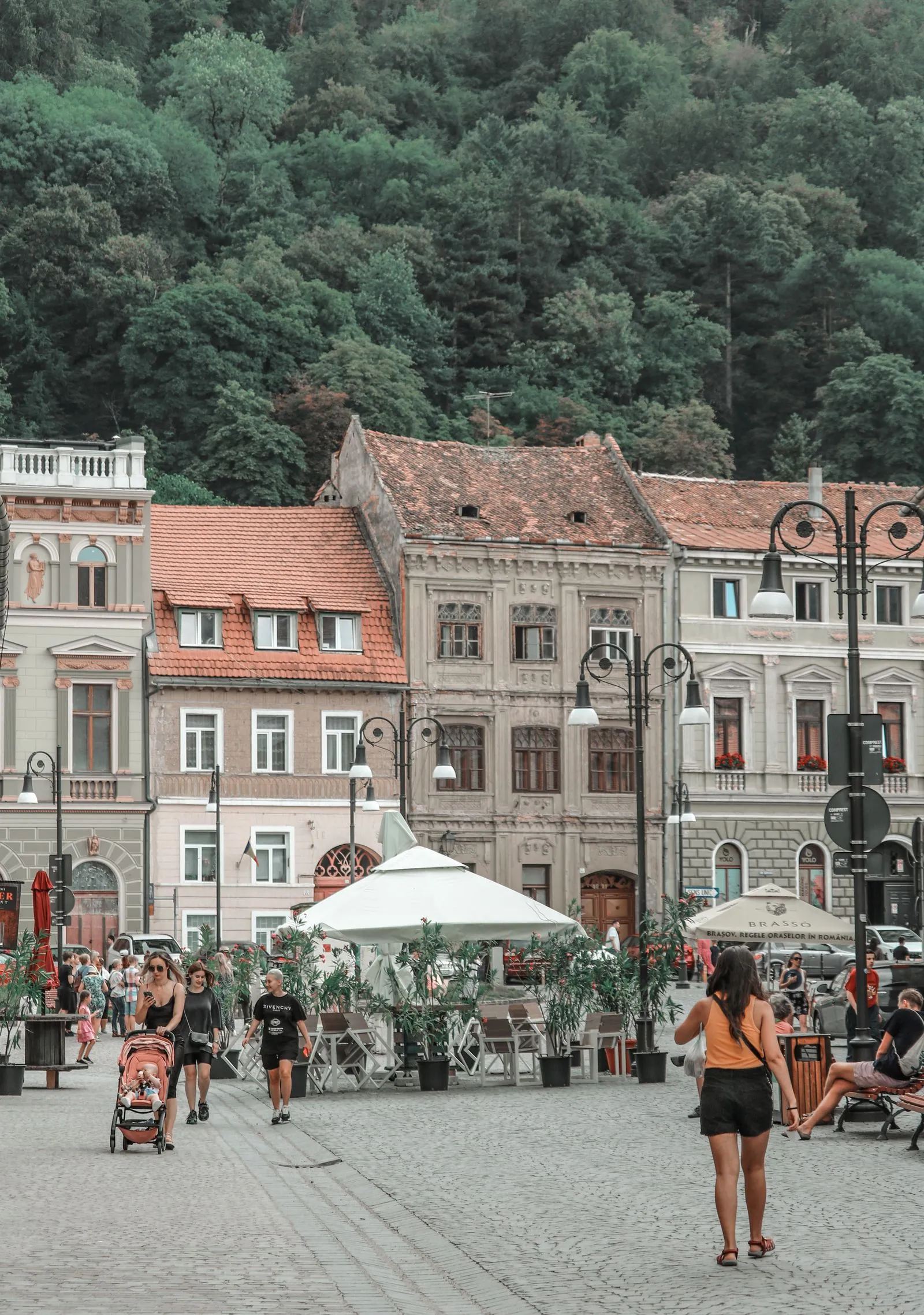 Stradă în centrul vechi al Brașovului, cu terase și Tâmpa în fundal