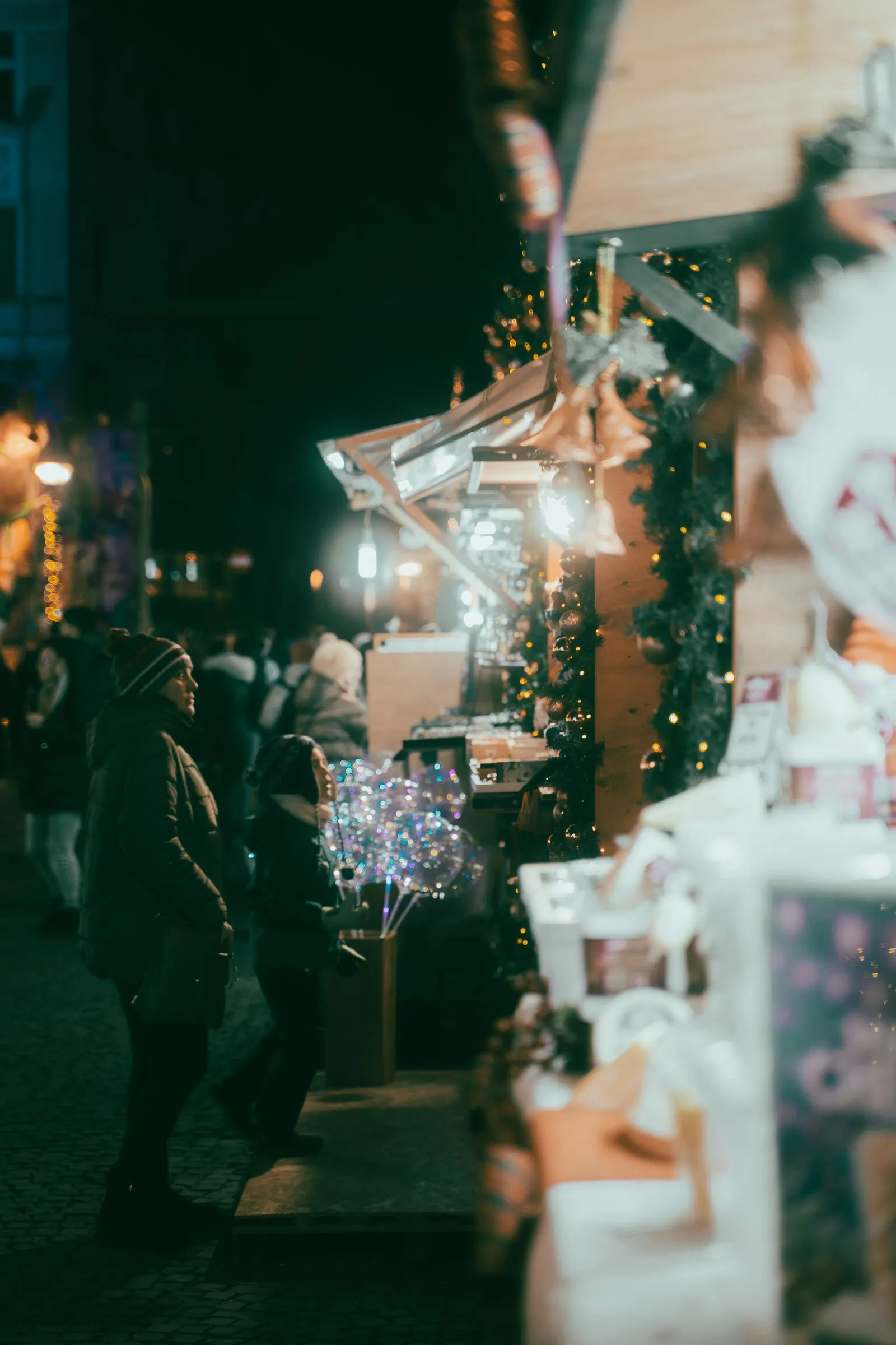 Căsuțele de lemn ale târgului de Crăciun din Cluj-Napoca, luminate seara