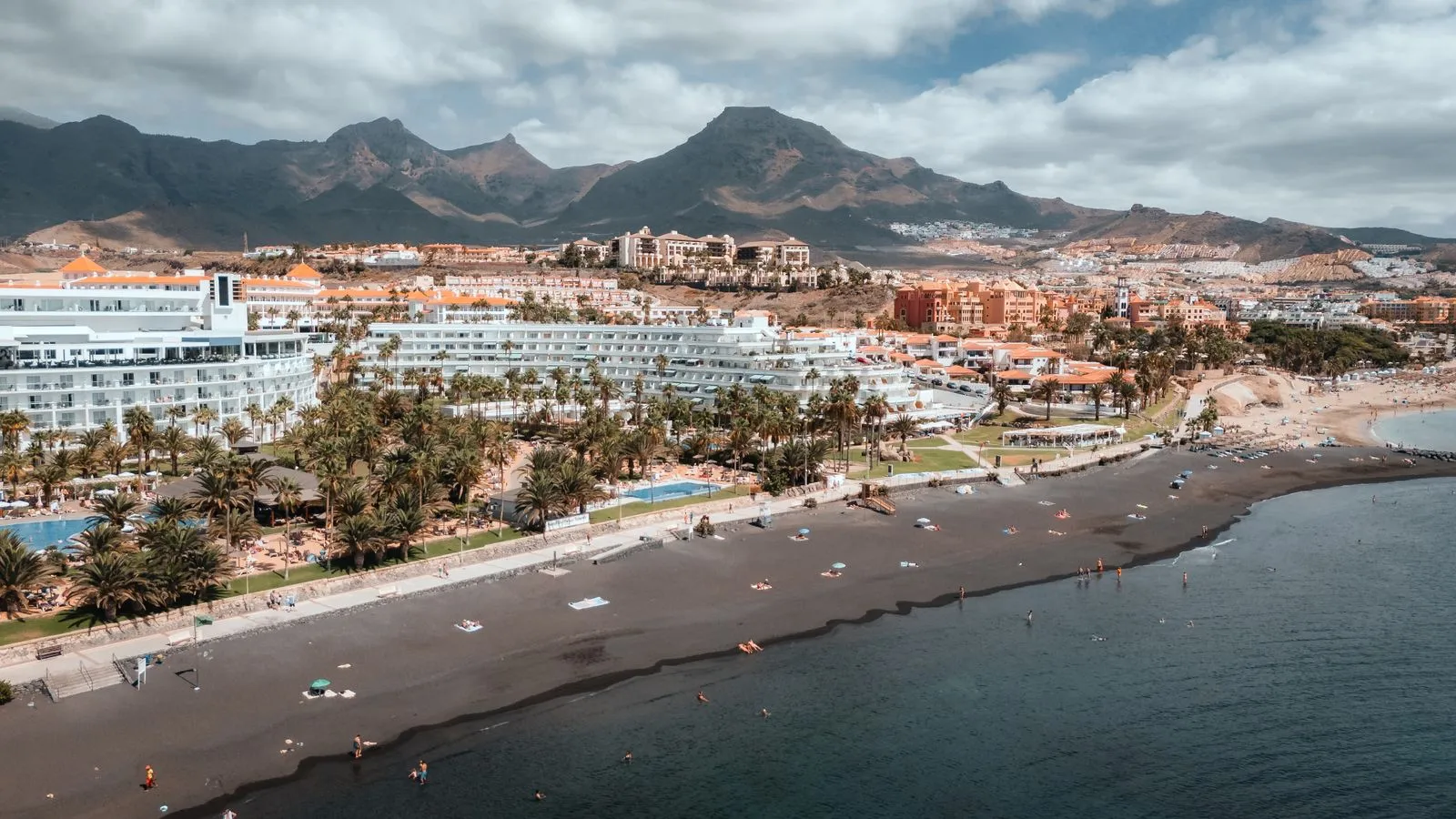 Vedere aeriană asupra plajei și hotelurilor din Costa Adeje, în sudul Tenerifei, cu munții în fundal