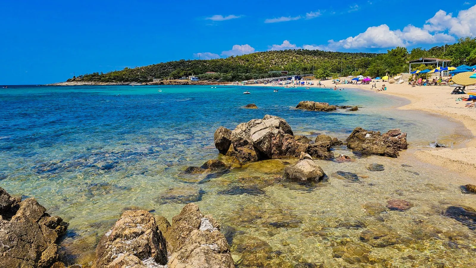 Plajă cu apă limpede și țărm stâncos pe insula Thassos