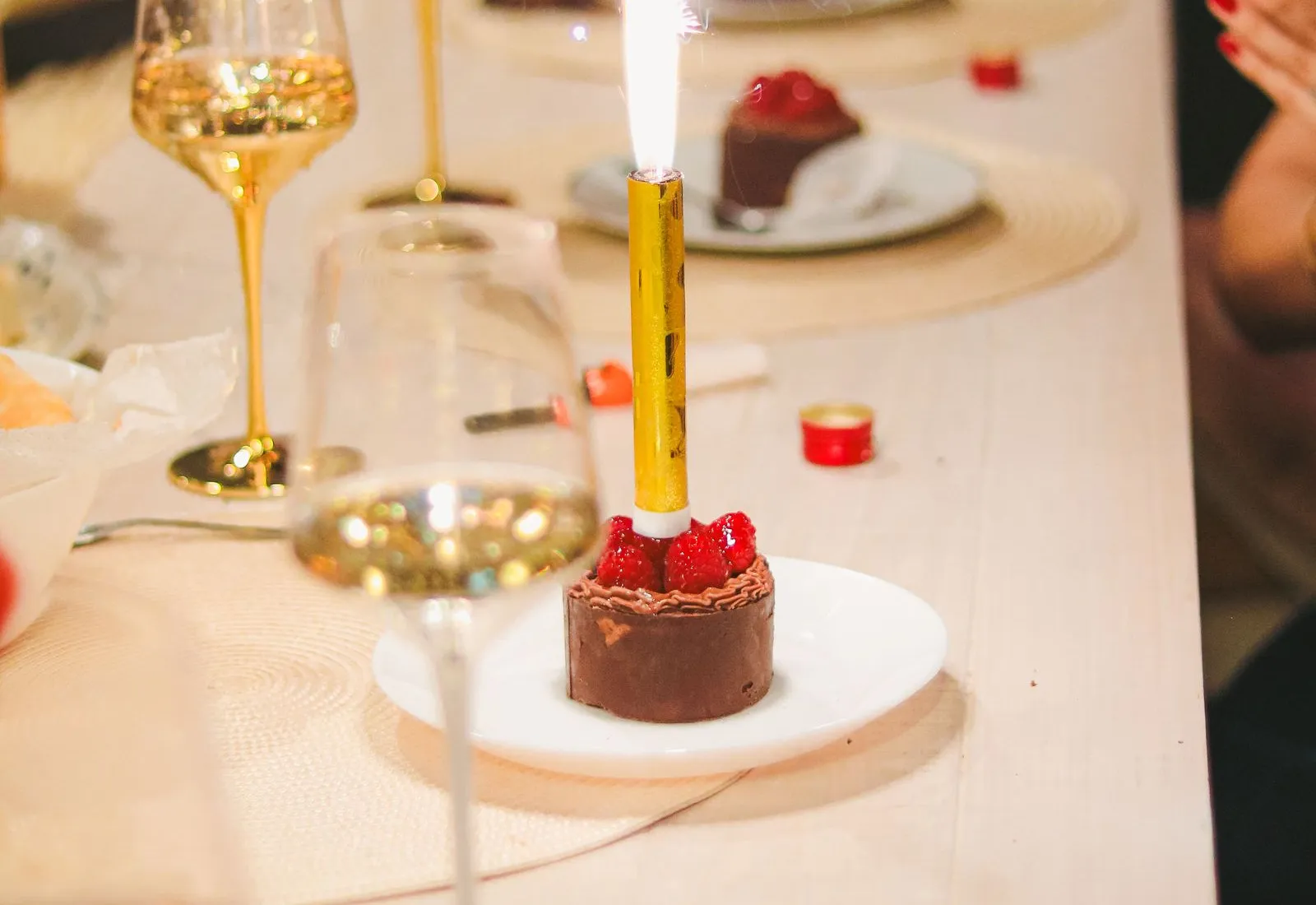 Desert cu artificii de tort pe masa unei petreceri aniversare, cu pahare de vin spumant