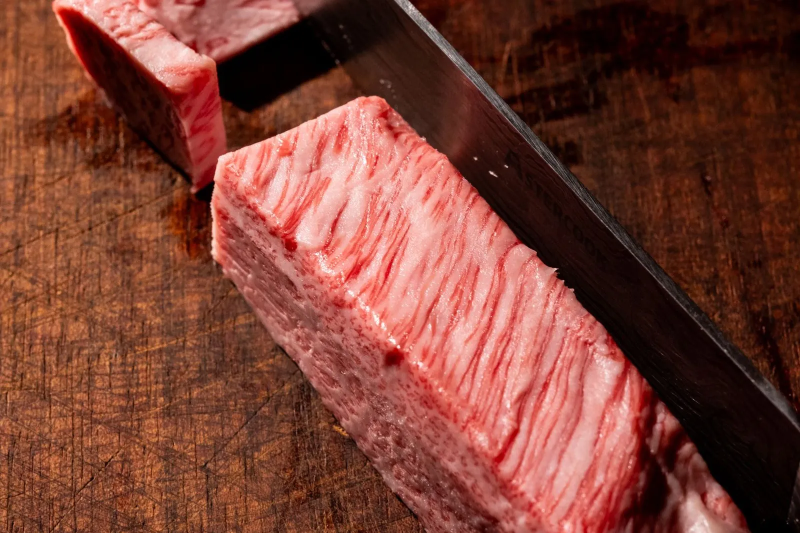Vită Wagyu A5 cu marmorare densă, tăiată pe un fund de lemn