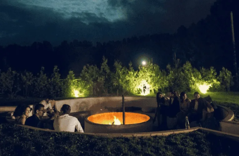 Invitați seara în jurul vetrei de foc din amfiteatrul în aer liber de la Wolkendorf BioHotel & Spa, lângă pădure
