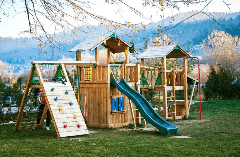 Locul de joacă pentru copii din curtea Wolkendorf BioHotel, cu tobogan și perete de cățărare, lângă Brașov