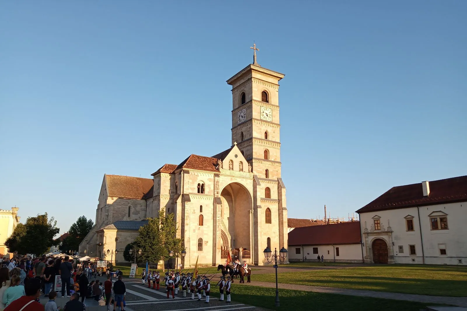 Catedrala Romano-Catolică Sfântul Mihail din Cetatea Alba Carolina la apus, cu vizitatori în piața din fața ei