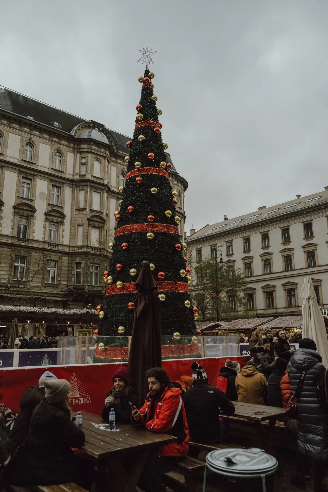 Bradul de Crăciun din Piața Sfântul Ștefan (Szent István tér) la târgul Advent Bazilika, cu mese și vizitatori