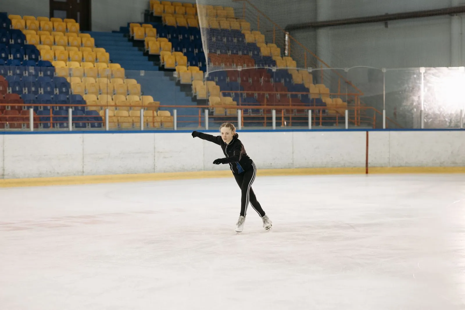 Patinatoare la un antrenament de patinaj artistic pe un patinoar acoperit